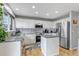 Well-lit kitchen featuring white cabinetry, granite countertops, and stainless steel appliances at 5075 Weeping Willow Cir, Highlands Ranch, CO 80130