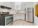 Bright kitchen with white cabinets, stainless steel appliances and tile floors at 1708 Akron St, Aurora, CO 80010