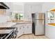 This Kitchen has a tile countertop, stainless refrigerator and a large window at 1708 Akron St, Aurora, CO 80010