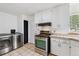 Bright laundry area featuring stainless steel appliances and tile floors at 1708 Akron St, Aurora, CO 80010