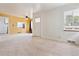 Bright living room with neutral paint, carpet and a view into the adjacent dining area and kitchen at 1708 Akron St, Aurora, CO 80010