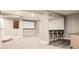 Finished basement with seating at the bar, a projector screen, and neutral carpet at 3473 Beeler St, Denver, CO 80238