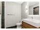 Modern bathroom with gray tile floors, gray accent wall, modern vanity, and lighted mirror at 3473 Beeler St, Denver, CO 80238
