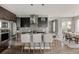 Modern kitchen with stainless steel appliances, a center island with bar stools, and a view to the dining area at 3473 Beeler St, Denver, CO 80238