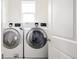 A laundry room featuring a stacked front load washer and dryer and a small window at 3473 Beeler St, Denver, CO 80238