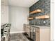 Basement wet bar with stainless steel beverage cooler, granite countertop, and mosaic tile backsplash at 3473 Beeler St, Denver, CO 80238