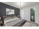 A bedroom with virtual staging, featuring a neutral color palette, art, and a view into a bathroom at 4076 S Carson St # H, Aurora, CO 80014