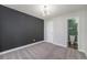 A carpeted bedroom features a modern light fixture and a door to a bathroom at 4076 S Carson St # H, Aurora, CO 80014