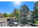 Balcony view of the neighborhood, including mature trees, parking, and a beautiful blue sky at 4076 S Carson St # H, Aurora, CO 80014