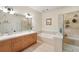 Bright bathroom features double sinks, a tub, and a separate glass shower enclosure at 2100 N Humboldt St # 208, Denver, CO 80205