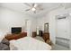 Bright bedroom features a ceiling fan, wooden dresser with television, and ensuite bathroom at 2100 N Humboldt St # 208, Denver, CO 80205