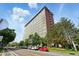 Tall, modern building with a red trim, surrounded by greenery and city street with cars parked along the side at 2100 N Humboldt St # 208, Denver, CO 80205