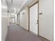 Well-lit hallway with neutral walls and carpet providing access to individual units at 2100 N Humboldt St # 208, Denver, CO 80205