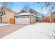 Two-car garage and charming curb appeal with snow-covered lawn at 12844 W Cross Dr, Littleton, CO 80127