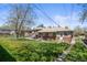 Backyard view shows a charming yard with yellow flowers in full bloom and brick home exterior at 5012 W 36Th Ave # 5, Denver, CO 80212