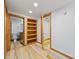 Bright hallway with wood flooring, built-in shelves, and doors to the bathroom and another room at 5012 W 36Th Ave # 5, Denver, CO 80212