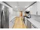 Modern kitchen with stainless steel appliances, white cabinets, and an adjacent open area at 5012 W 36Th Ave # 5, Denver, CO 80212