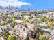 Aerial view of building with city in the background, surrounded by trees at 1699 N Downing St # 302, Denver, CO 80218