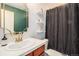 Bathroom with patterned shower curtain, shelves, and decorative gold mirror at 1699 N Downing St # 302, Denver, CO 80218