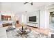 Modern living room with hardwood floors, TV, an open kitchen, and natural light at 1699 N Downing St # 302, Denver, CO 80218