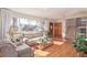 Bright living room with large windows, hardwood floors, sofa, and cozy armchair at 11237 W 59Th Ave, Arvada, CO 80004