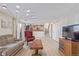 Spacious living room featuring sliding glass doors, wood floors, brick fireplace, and television at 11237 W 59Th Ave, Arvada, CO 80004