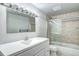 Bathroom featuring a tub with glass sliding doors, tiled walls, and a vanity with lighting at 600 Manhattan Dr # 4C, Boulder, CO 80303