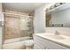 Bathroom featuring a tub with glass sliding doors, tiled walls, and a white vanity at 600 Manhattan Dr # 4C, Boulder, CO 80303
