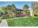 Multi-story apartment building with balconies, mature trees, and a well-maintained lawn at 600 Manhattan Dr # 4C, Boulder, CO 80303