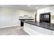 Bright kitchen featuring white cabinets, gray countertops, black refrigerator, and tiled flooring at 600 Manhattan Dr # 4C, Boulder, CO 80303