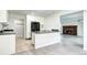 Open kitchen with white cabinets, gray countertop, black refrigerator, and view to a living room fireplace at 600 Manhattan Dr # 4C, Boulder, CO 80303