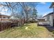 Spacious backyard with mature trees, grass, and a wooden fence at 8334 Allison Ct, Arvada, CO 80005