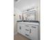 Modern bathroom vanity with white cabinets, a sleek mirror, and stylish hexagon backsplash at 8334 Allison Ct, Arvada, CO 80005