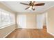 Bright bedroom featuring a ceiling fan, large window and gleaming hardwood floors at 4545 E Harvard Ave, Denver, CO 80222