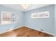 This cozy bedroom is painted in a light blue with gleaming hardwood floors and has natural light from two windows at 4545 E Harvard Ave, Denver, CO 80222