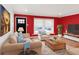 Bright living room featuring hardwood floors, neutral furniture and red accent wall at 4545 E Harvard Ave, Denver, CO 80222