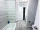 Bathroom with white tiled shower, white toilet and light gray tiled floors at 12223 E Ford E Ave # 12223, Aurora, CO 80012