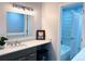 Well-lit bathroom featuring a modern vanity, mirror, and a tub with tile at 12223 E Ford E Ave # 12223, Aurora, CO 80012