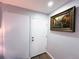 Hallway with a white door, wood-style flooring and decorative art hung on the wall at 12223 E Ford E Ave # 12223, Aurora, CO 80012