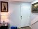 Hallway with a white door, wood-style flooring, a stairwell, and decorative art hung on the wall at 12223 E Ford E Ave # 12223, Aurora, CO 80012