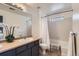 Bright bathroom featuring a shower-tub combo, vanity, and a large mirror at 2541 S Bahama Cir # F, Aurora, CO 80013