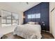 Serene bedroom featuring a stylish accent wall, large window, and comfortable bed at 2541 S Bahama Cir # F, Aurora, CO 80013