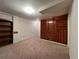 Spacious basement living area with wood accent wall and built-in shelves at 3000 S Newland St, Denver, CO 80227