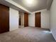 Unfinished basement with multiple doors and carpet flooring at 3000 S Newland St, Denver, CO 80227