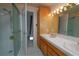 Bright bathroom with tile shower, dual sink vanity, and an open door to the hall at 3000 S Newland St, Denver, CO 80227