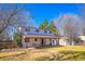 A view of the back exterior of the home with a large backyard, patio, and storage shed at 3000 S Newland St, Denver, CO 80227