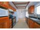 Traditional kitchen featuring wooden cabinetry and black appliances at 3000 S Newland St, Denver, CO 80227