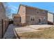 Back of the home featuring neutral siding, a stone accent wall, a fenced yard, and a concrete patio at 6472 N Dunkirk Ct, Aurora, CO 80019