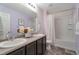 Bathroom with double sinks, framed mirror, tub, and shower at 6472 N Dunkirk Ct, Aurora, CO 80019