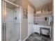 Bright bathroom with stylish vanity, glass shower, and open shelving provides ample storage space at 6472 N Dunkirk Ct, Aurora, CO 80019